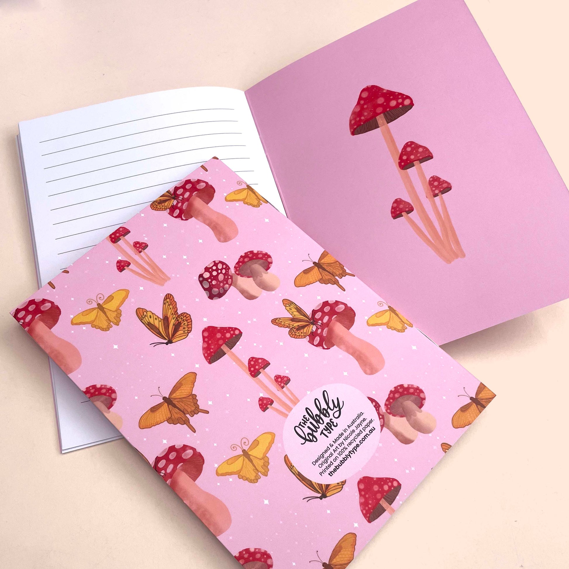 Handmade A5 notebook with mushroom and butterflies pattern cover, featuring original artwork by Nicole Jayne for The Bubbly Type, 32 lined pages on 120gsm premium uncoated paper, eco-friendly recycled matte finish, ideal for notes, journaling, and gifts.