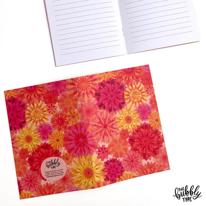 Handmade A5 notebook with orange flower pattern cover, featuring original artwork by Nicole Jayne for The Bubbly Type, 32 lined pages on 120gsm premium uncoated paper, eco-friendly recycled matte finish, ideal for notes, journaling, and gifts.